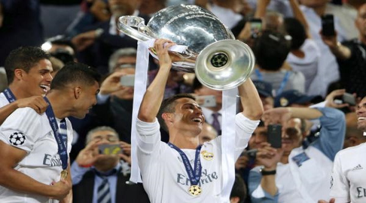 Real Madrid's Cristiano Ronaldo holds up the trophy after the Champions League final soccer match between Real Madrid and Atletico Madrid at the San Siro stadium in Milan, Italy, Saturday, May 28, 2016. Real Madrid won 5-4 on penalties after the match ended 1-1 after extra time. (AP Photo/Luca Bruno)