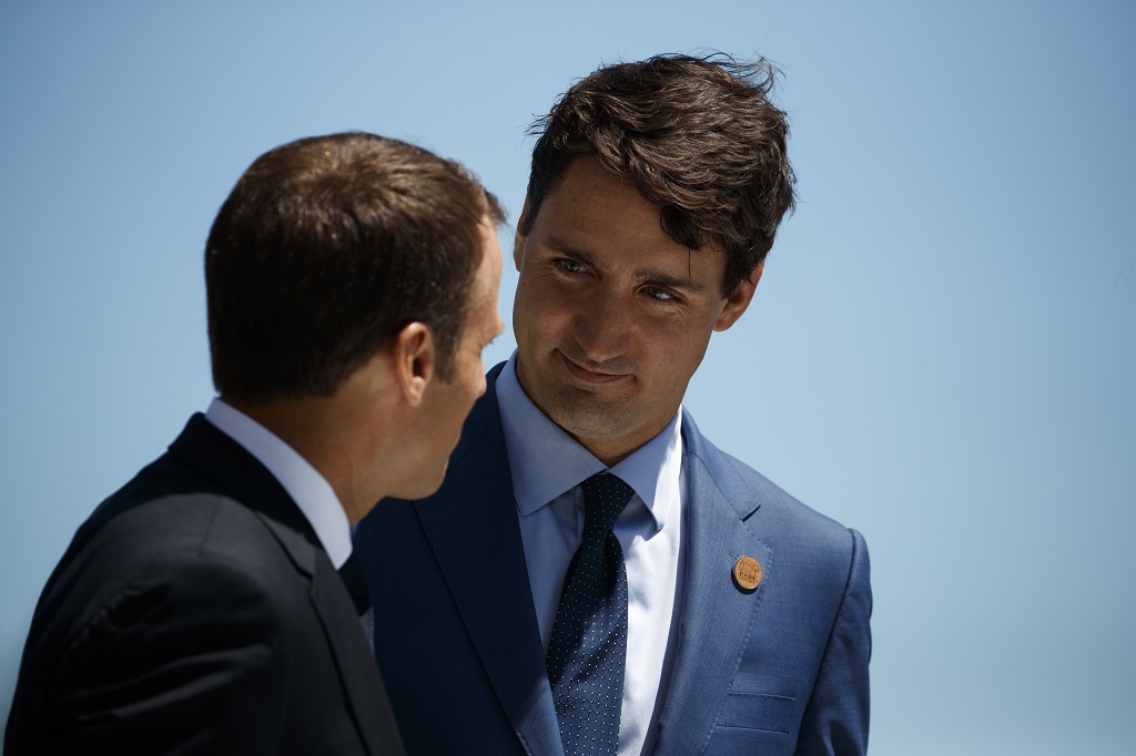 Canadian Prime Minister Justin Trudeau speaks with French President Emmanuel Macron during a G-7 summit welcome ceremony, Friday, June 8, 2018, in Charlevoix, Canada. (AP Photo/Evan Vucci)
