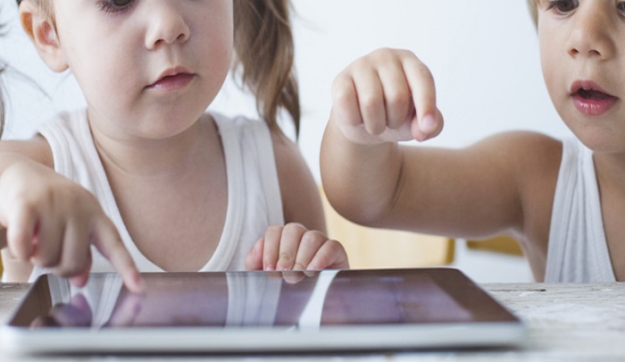 Two small kids using a tablet