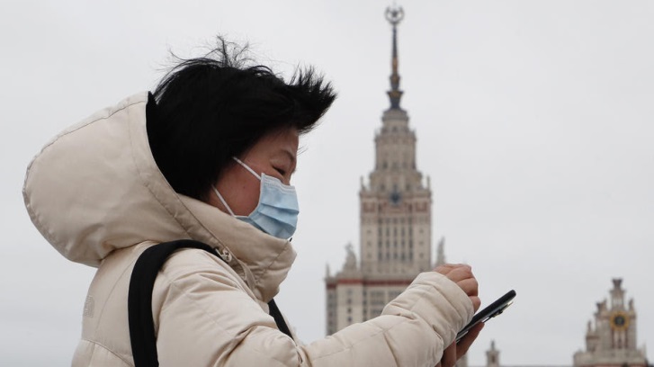epa08158826 A Chinese tourist wearing a medical protection mask walks at the Vorobyovy Gory (Sparrow Hills) park in Moscow, Russia, 24 January 2020. All passenger flights to Moscow from China's Wuhan were suspended on 24 January over coronavirus fears. The outbreak of coronavirus has so far claimed 26 lives and infected more than 800 others, according to media reports. The virus has so far spread to the USA, Thailand, South Korea, Japan, Singapore and Taiwan. EPA-EFE/MAXIM SHIPENKOV