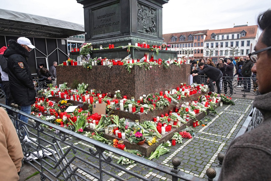 epa08237701 People place flowers and candles at a makeshift memorial for the racist terror attacks in Hanau, Germany, 22 February 2020. At least nine people were killed on 19 February 2020 in two shootings at shisha bars in Hanau, police said. The perpetrator, a suspected far-right extremist, was reportedly found dead later at his home along with the body of his mother.  EPA-EFE/ARMANDO BABANI