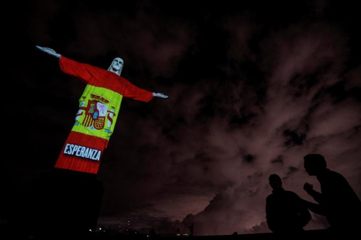 epa08359859 Christ the Redeemer statue is illuminated in a Spanish flag during a religious ceremony to celebrate Easter Sunday, on Mount Corcovado, Rio de Janeiro, Brazil, 12 April 2020. EPA-EFE/Antonio Lacerda