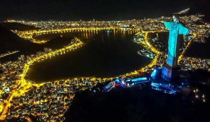 epaselect epa08359875 Christ the Redeemer statue is illuminated with the projection of a health worker's uniform during a religious ceremony to celebrate Easter Sunday, on Mount Corcovado, Rio de Janeiro, Brazil, 12 April 2020.  EPA-EFE/Antonio Lacerda