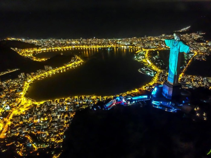 epaselect epa08359875 Christ the Redeemer statue is illuminated with the projection of a health worker's uniform during a religious ceremony to celebrate Easter Sunday, on Mount Corcovado, Rio de Janeiro, Brazil, 12 April 2020. EPA-EFE/Antonio Lacerda