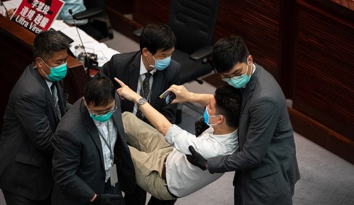 epa08409366 Pro-democracy lawmaker Jeremy Tam, C, is removed from a House Committee by security guards at the Legislative Council in Hong Kong, China, 08 May 2020. Several pro-democracy legislators were dragged out of the chamber by security guards as the pro-democracy and the pro-Beijing camps scuffled for control of the House Committee which has been gridlocked for months. The House Committee is responsible for scrutinising bills before sending them for a final vote.  EPA-EFE/JEROME FAVRE