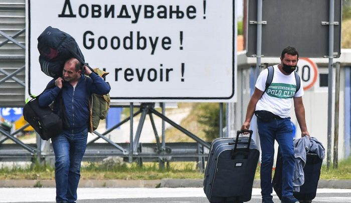 epa08490551 People wearing protective masks walk with their luggage between Serbian and North Macedonian border crossing Tabanovce near Kumanovo, North Macedonia, 17 June 2020. North Macedonia?s Government has decided to open all border crossings starting on 17 June 2020. Passengers can cross the borders with condition to show a valid negative PCR test and go in 14 day mandatory self-isolation. Foreigners transiting the country for a period of maximum 5 hours can use all border crossings. The number of newly infected COVID-19 patients in the North Macedonia is still more than one hundred per day in last three weeks, which is a big number for the small Balkan country.  EPA-EFE/GEORGI LICOVSKI