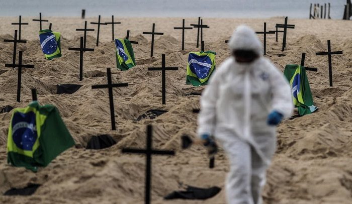 epaselect epa08479378 An Activist places one hundred and ten crosses, as a way of denouncing the errors made by the Government in managing the coronavirus crisis, during a protest organized by the NGO Rio de Paz, on Copacabana beach , Rio de Janeiro, Brazil, 11 June 2020.  EPA-EFE/ANTONIO LACERDA