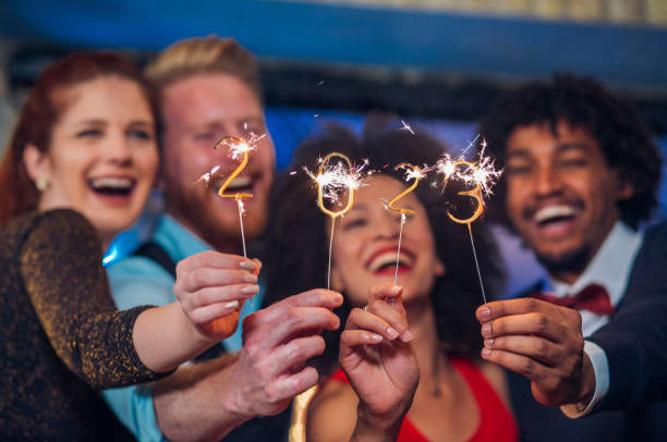 Young happy people looking at sparklers in their hands
