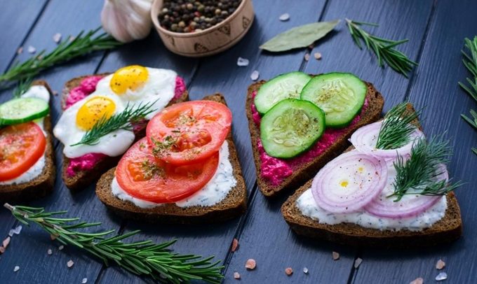 Smorgasbord. Open sandwiches with different  toppings on the dark wooden table. Healthy food. Diet.